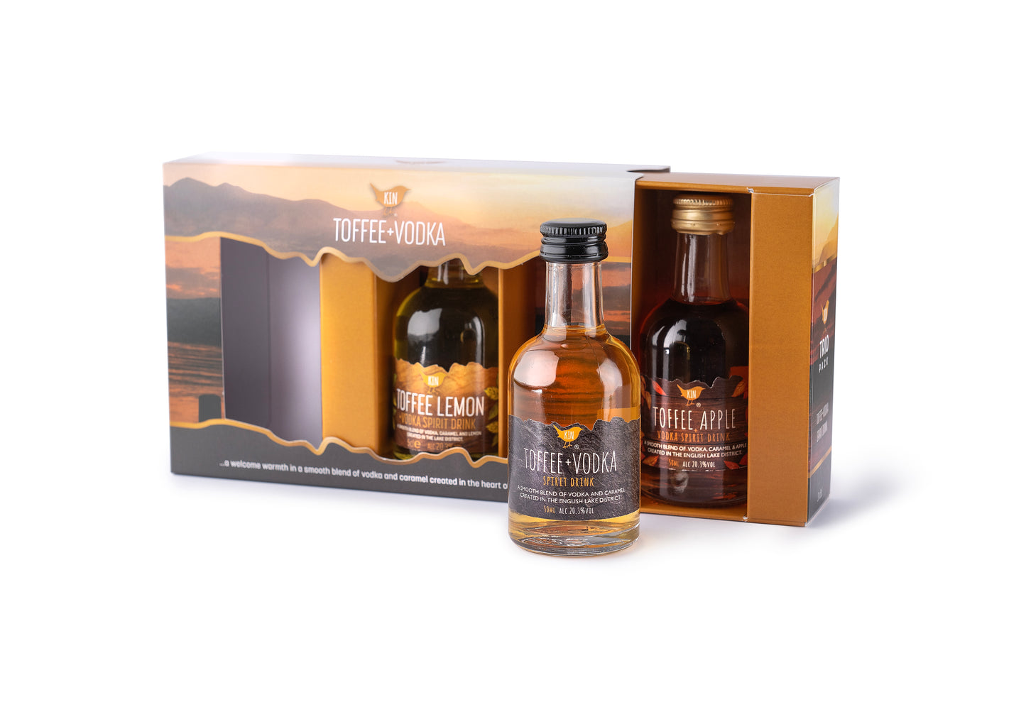 A 5cl bottle of original Kin Toffee Vodka stands in front of a Trio Gift pack in full colour printed box with a lake district view in background. Slide out tray holding two 5cl bottles of Kin Toffee Apple Vodka and Kin Toffee Lemon Vodka
